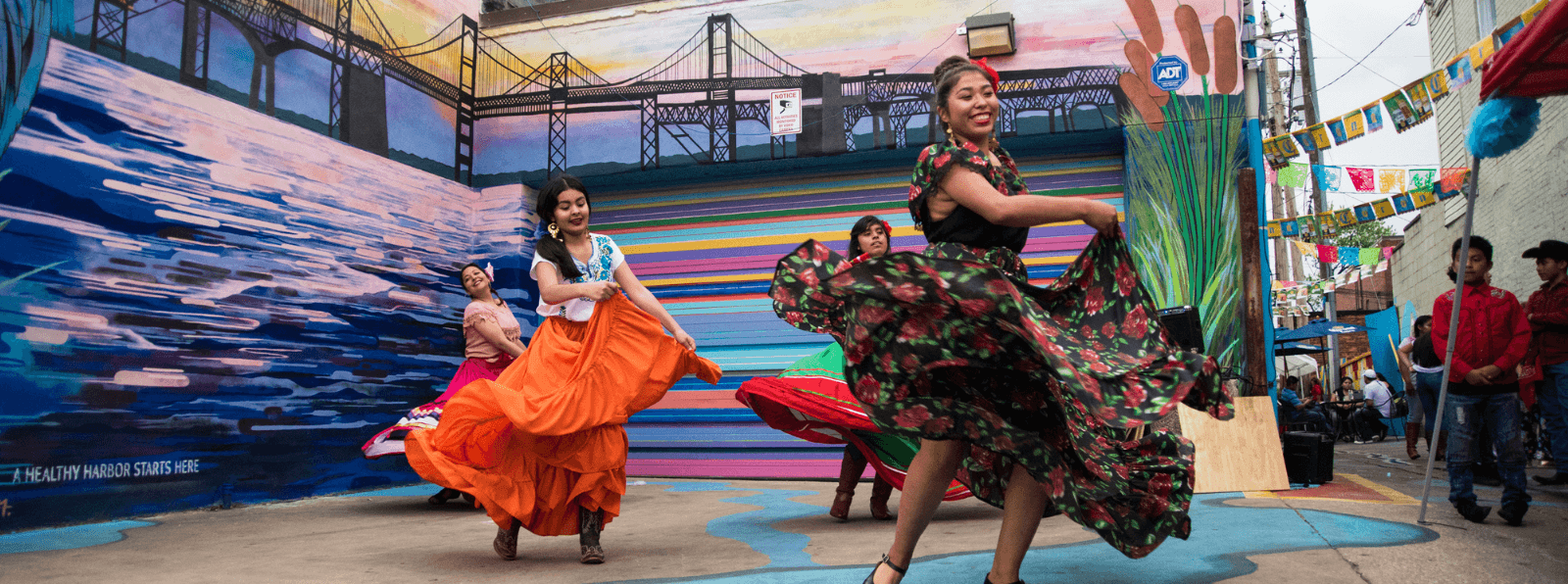 Women dancing outside in brightly colored dresses