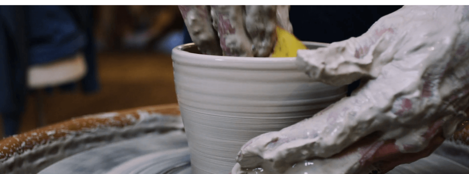 Hand spinning clay on a pottery wheel