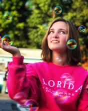 2021 Maryland State POL Champion Kate Maerten looks up at the sky in awe of bubbles surrounding them.
